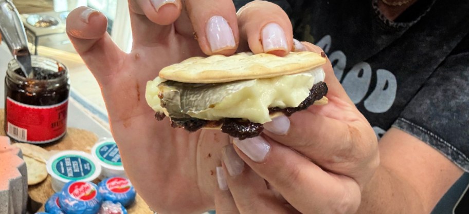 smashing a briw s'more together with crackers