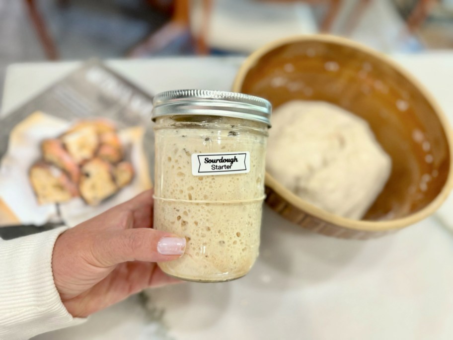 woman holding a sourdough starter