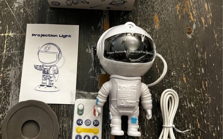 an astronaut galaxy projector shown with remote control power cord and instruction manual
