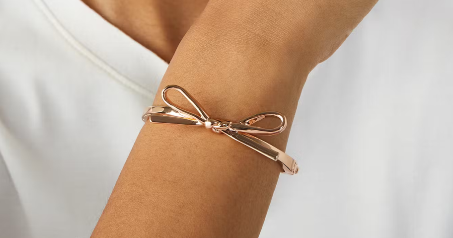 Kate Spade Skinny Mini Bow Bangle on a woman's wrist