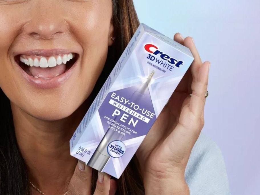 woman holding Crest 3D White Easy-To-Use Teeth Whitening Pen box