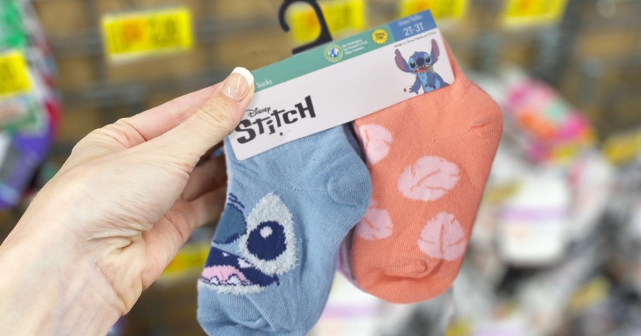 hand holding a pack of disney stitch print socks in store