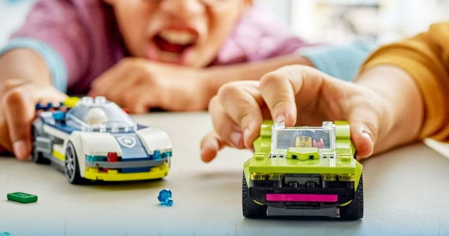 two kids playing with LEGO City Police Car and Muscle Car Chase set on table