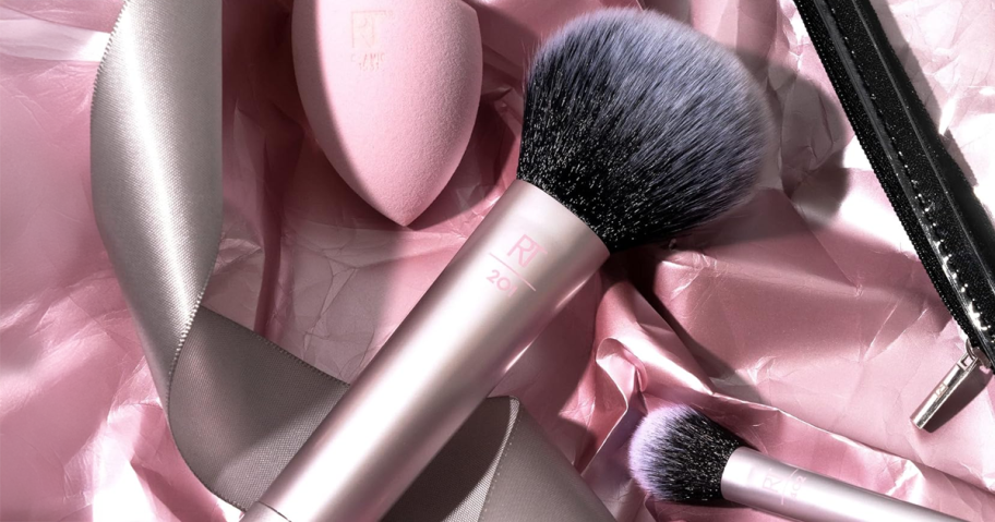 set of makeup brushes and a pink makeup sponge