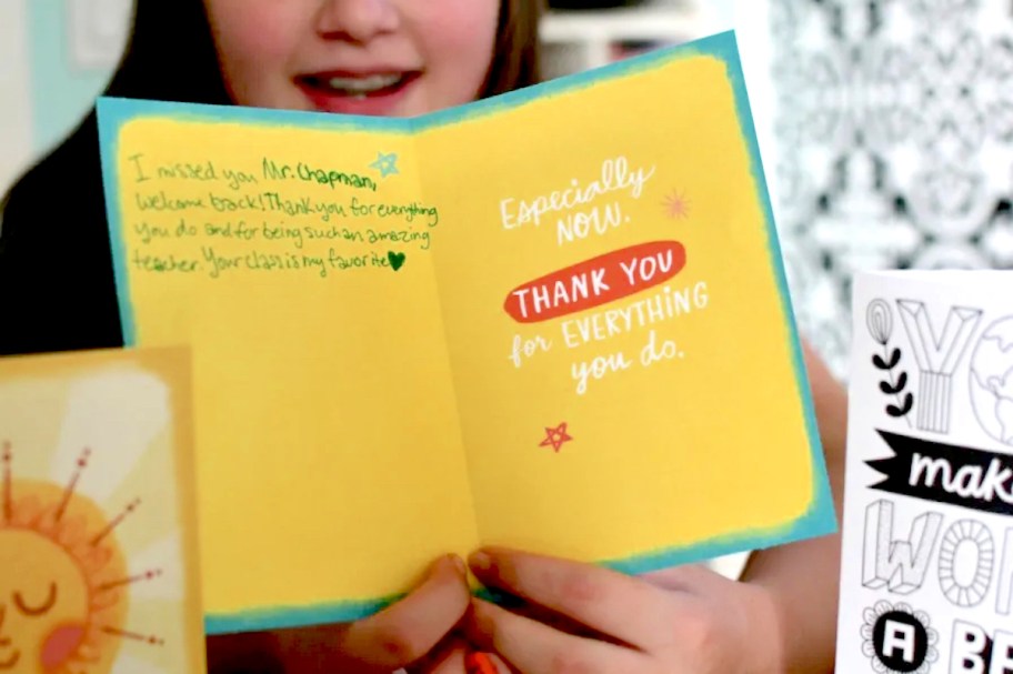 kid holding a card for a teacher