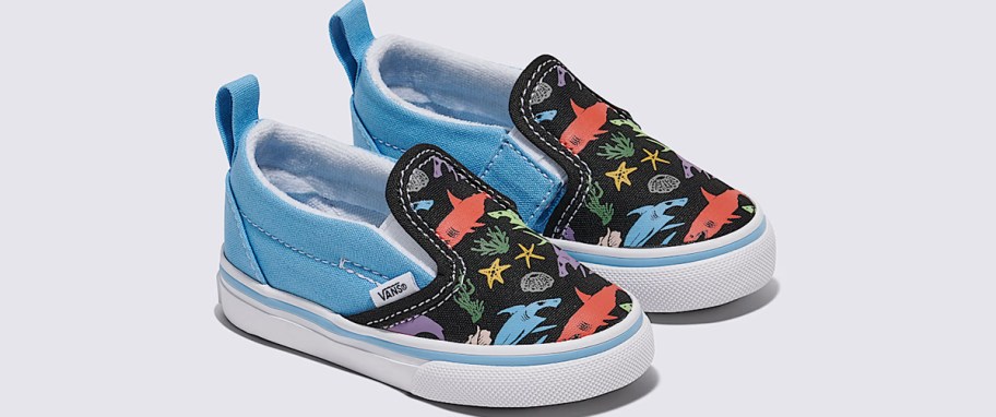pair of blue and black shark print slip on sneakers