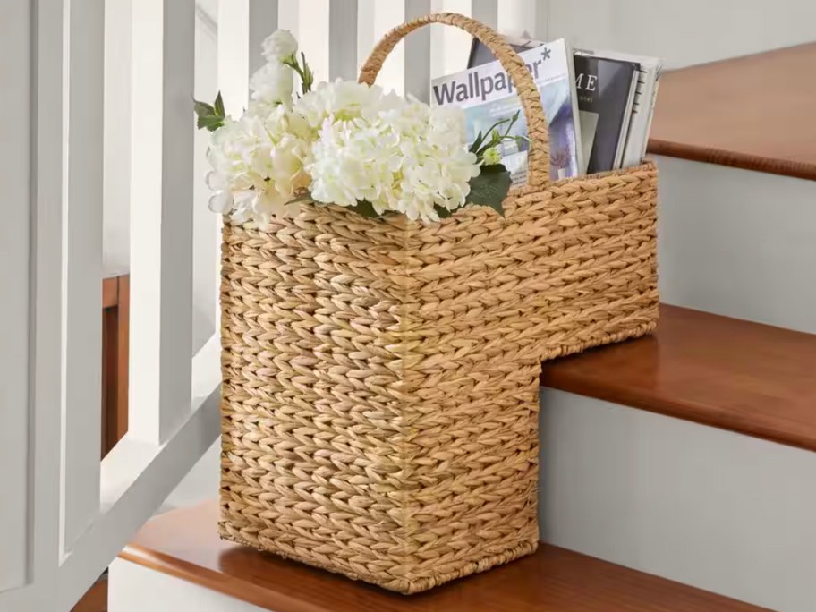 wick storage basket sitting on stairs with flowers