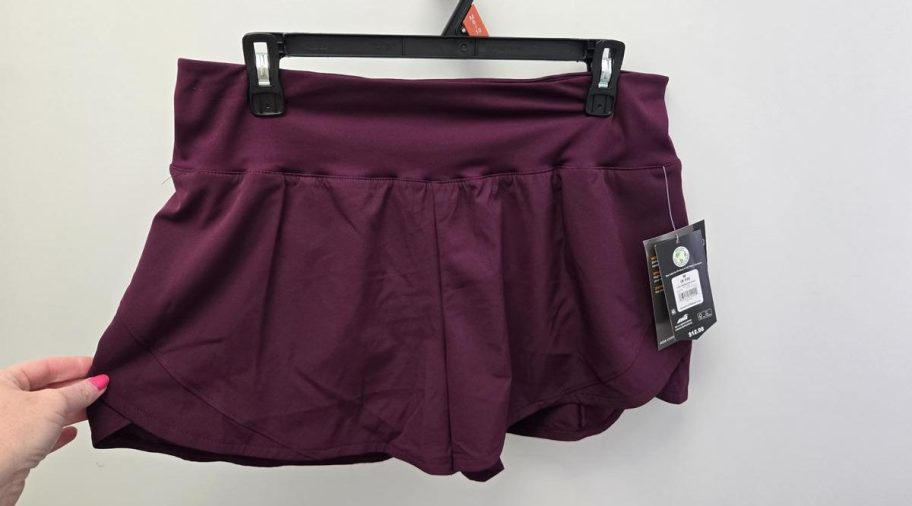  athletic shorts with a wide compression waistband, shown on a hanger with tags attached.