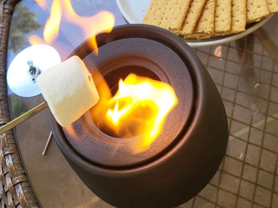 roasting marshmallow over a mini tabletop fire pit