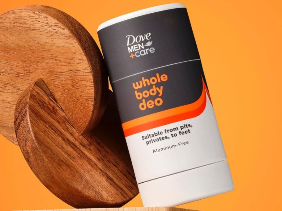 a container of Dove Men+Care Whole Body deodorant next to a decorative wood piece