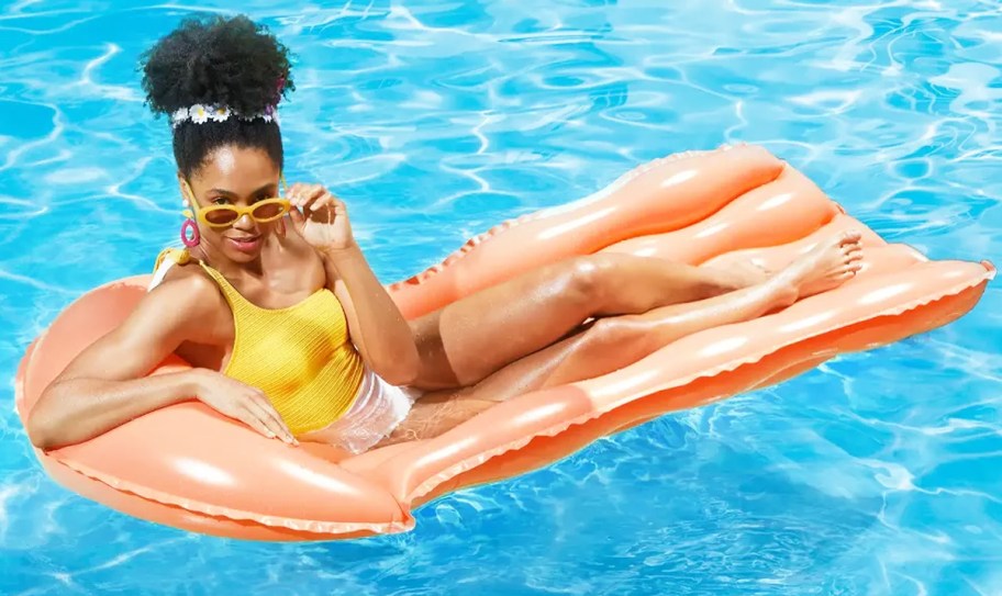 woman lounging on an orange pool float