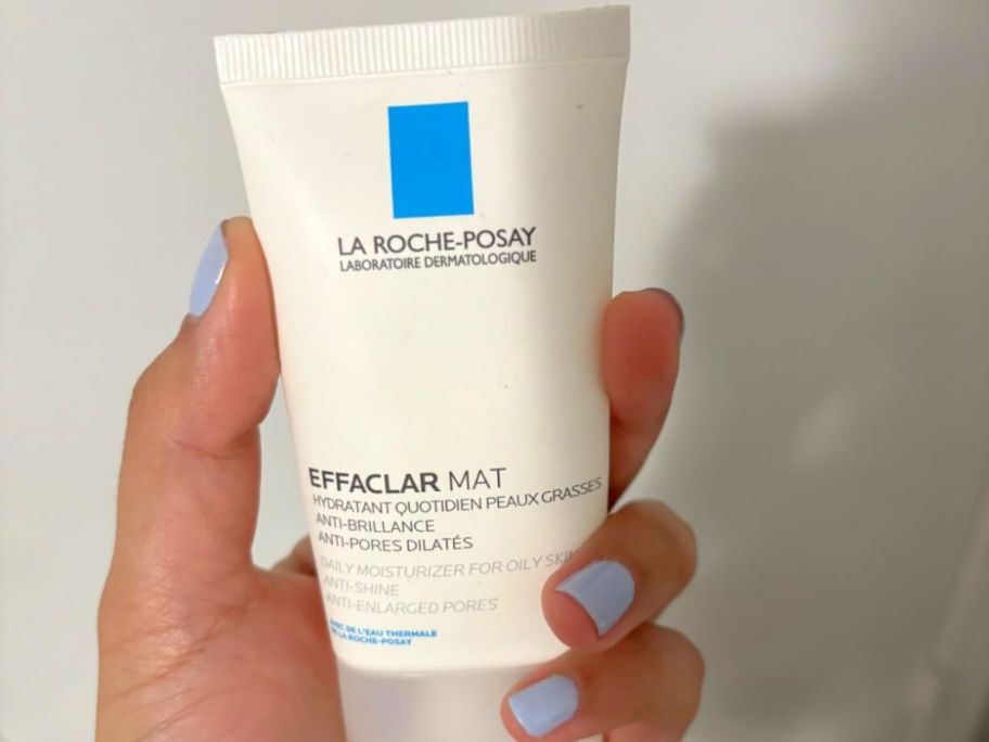 Hand holding a tube of La Roche-Posay Effaclar Mat Daily Moisturizer For Oily Skin