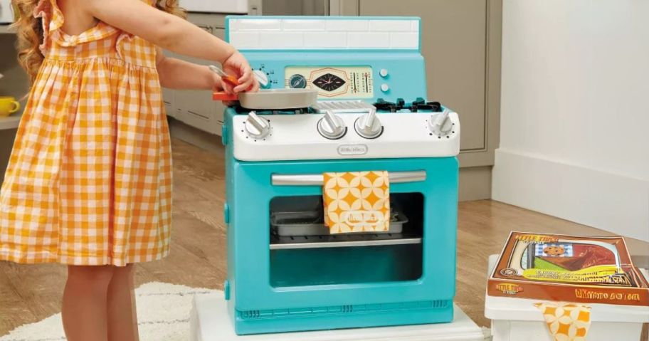 kid laying with Little Tikes Retro '50s Inspired Oven Realistic Pretend Play Kitchen Appliance