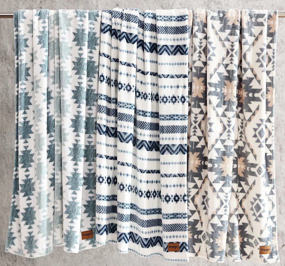 printed blankets hanging from a rod