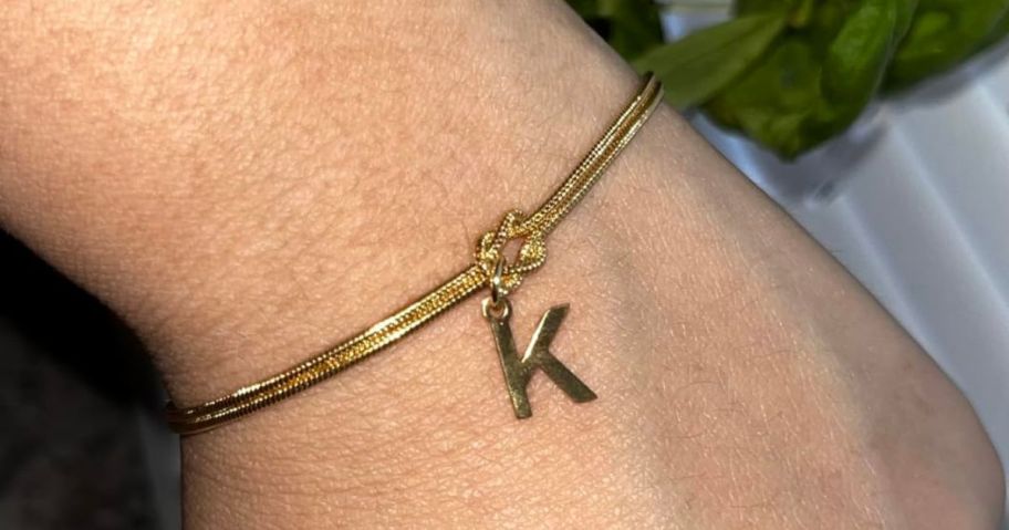 woman wearing gold Decholly Initial Charm Bracelet on wrist