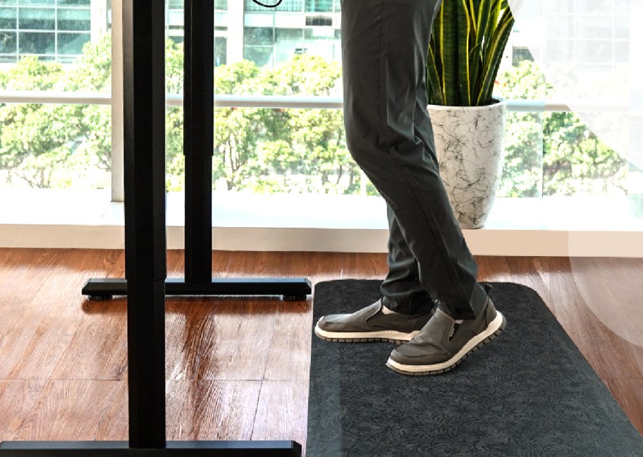 person standing on an anti-fatigue comfort mat at their standing desk