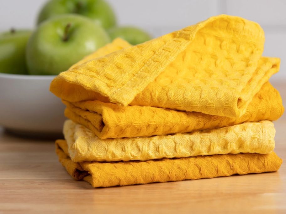 yellow dishcloths stacked on top of each other on counter