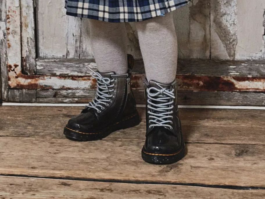 child wearing Dr. Martens Toddler 1460 Gradient Glitter Leather Lace-Up Boots on wooden floor