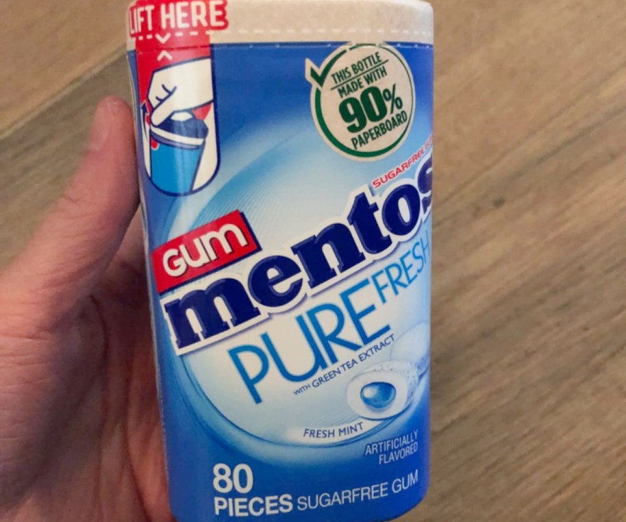 holding a recyclable container of mentos gum