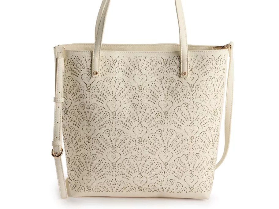 a cream color tote bag with embossed floral leather design