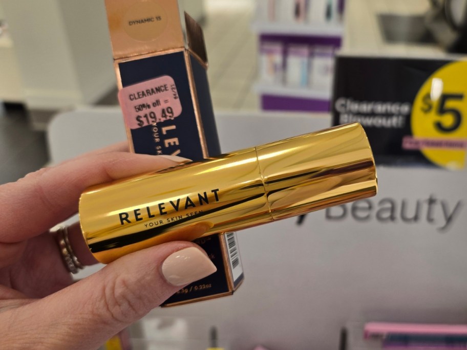 hand holding a tube and box for a relevant foundation stick in store