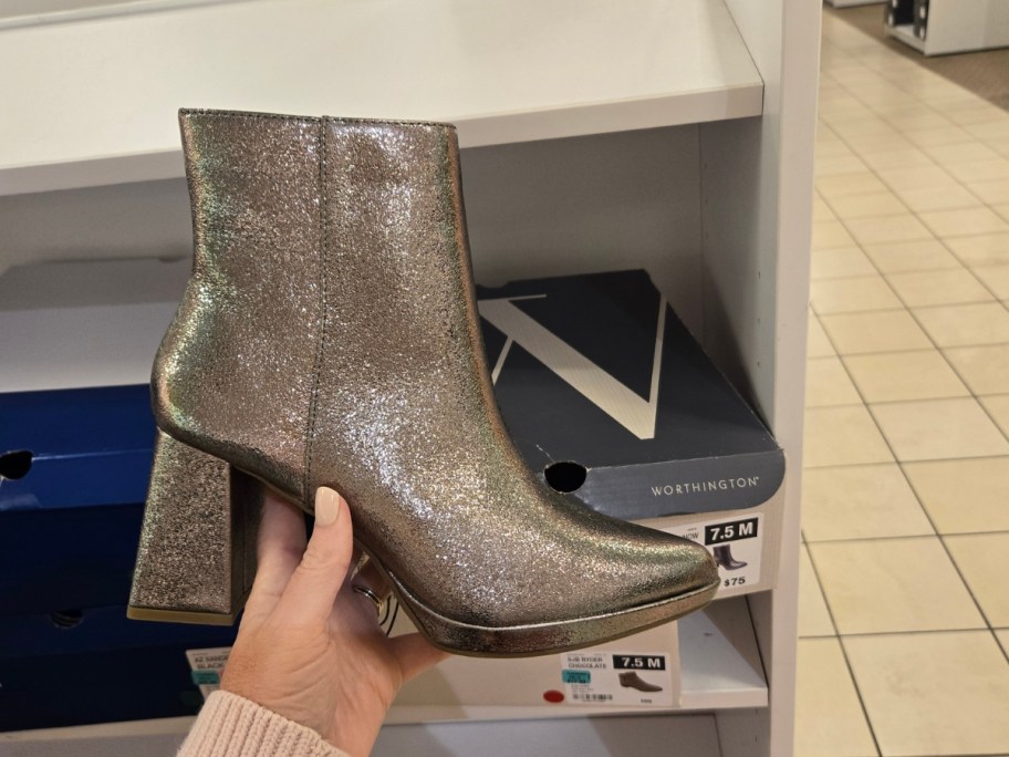 hand holding a women's high heel boot