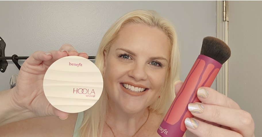 Woman holding Benefit cosmetics bundle with brush
