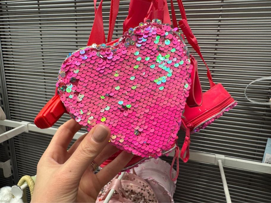 A person holding a Cat & Jack Girls Heart Shaped Flip Sequin Crossbody