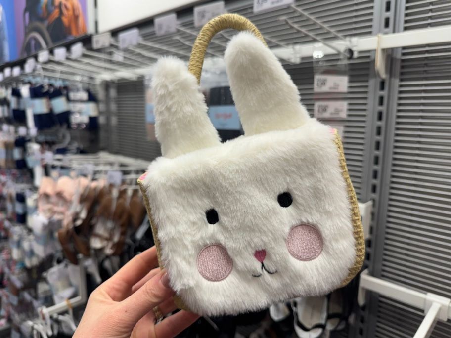A person holding a Cat & Jack Toddler Bunny Paper Straw Tote Handbag