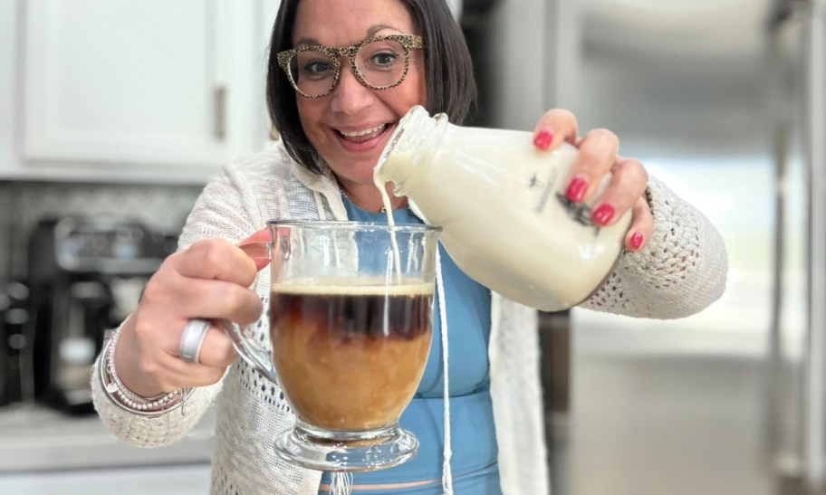 woman pouring homemade coffee creamer into coffee 