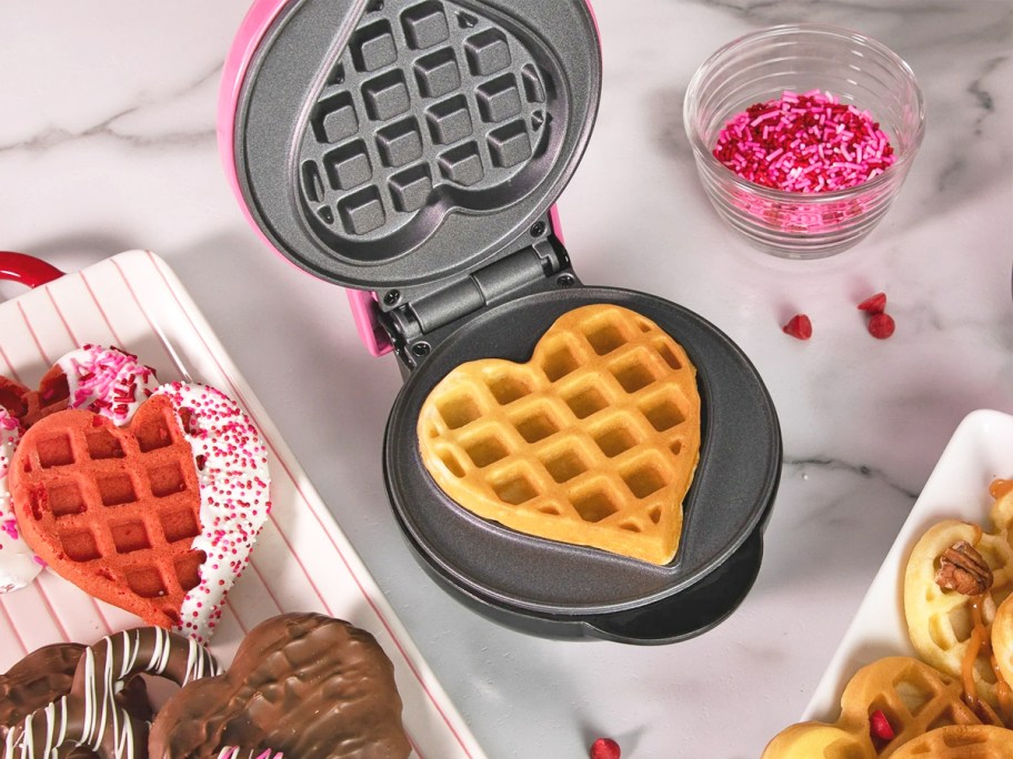heart-shaped waffle on a black and pink waffle maker