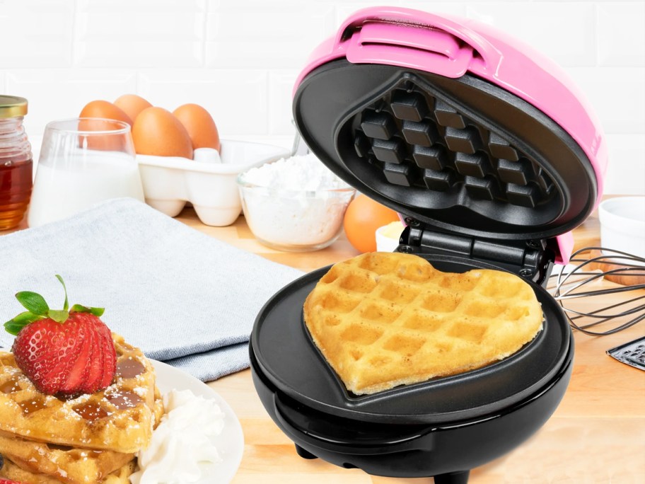 heart-shaped waffle on a black and pink waffle maker