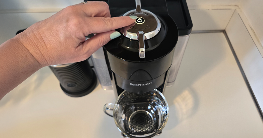 person pressing button on Nespresso Evoluo Coffee & Espresso Maker