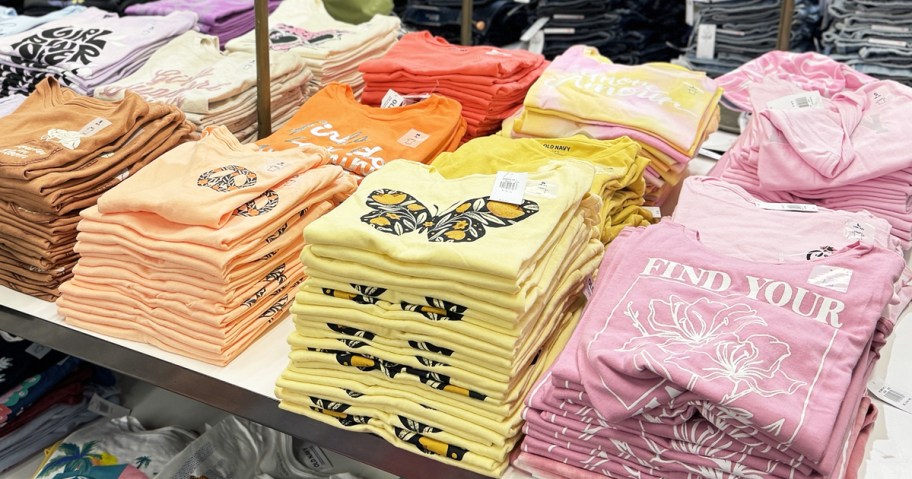 store display table full of folded graphic tees