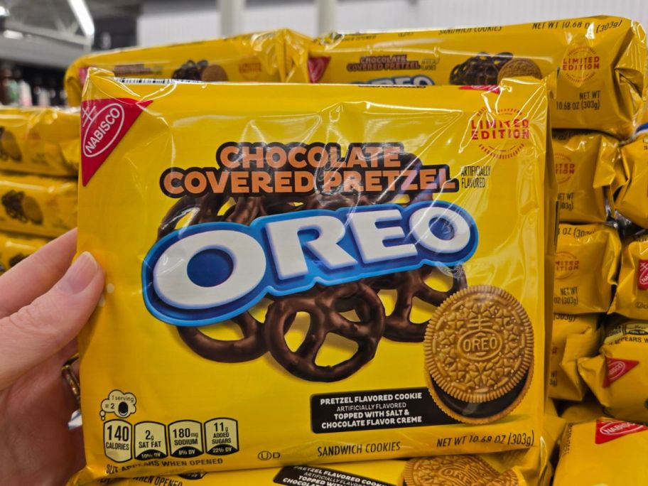A woman holding a bag of Oreo cookies 