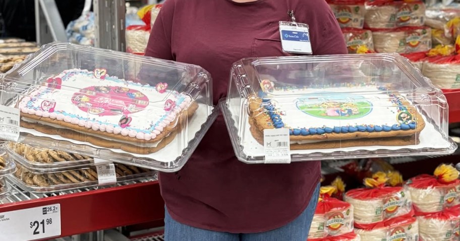 sams club employee holding up two cookie cakes