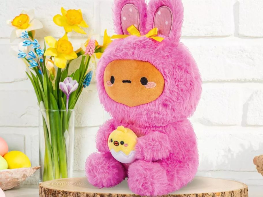 A plush bunny on a counter with daffodils 