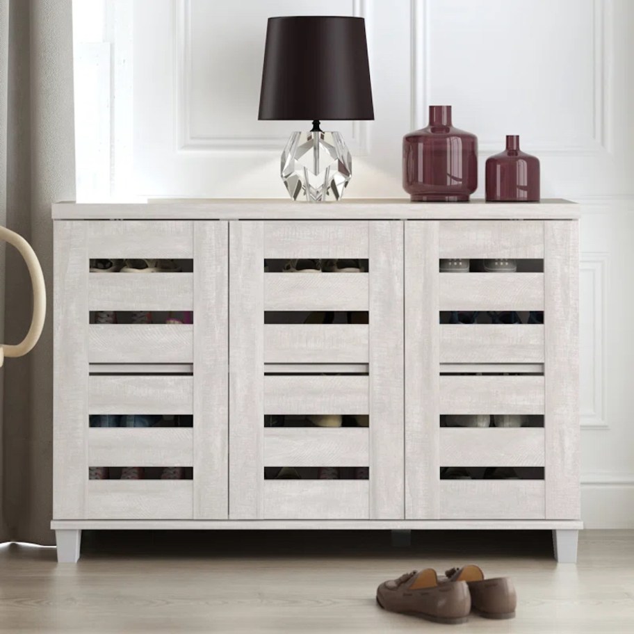 storage cabinet with lamp on top against wall