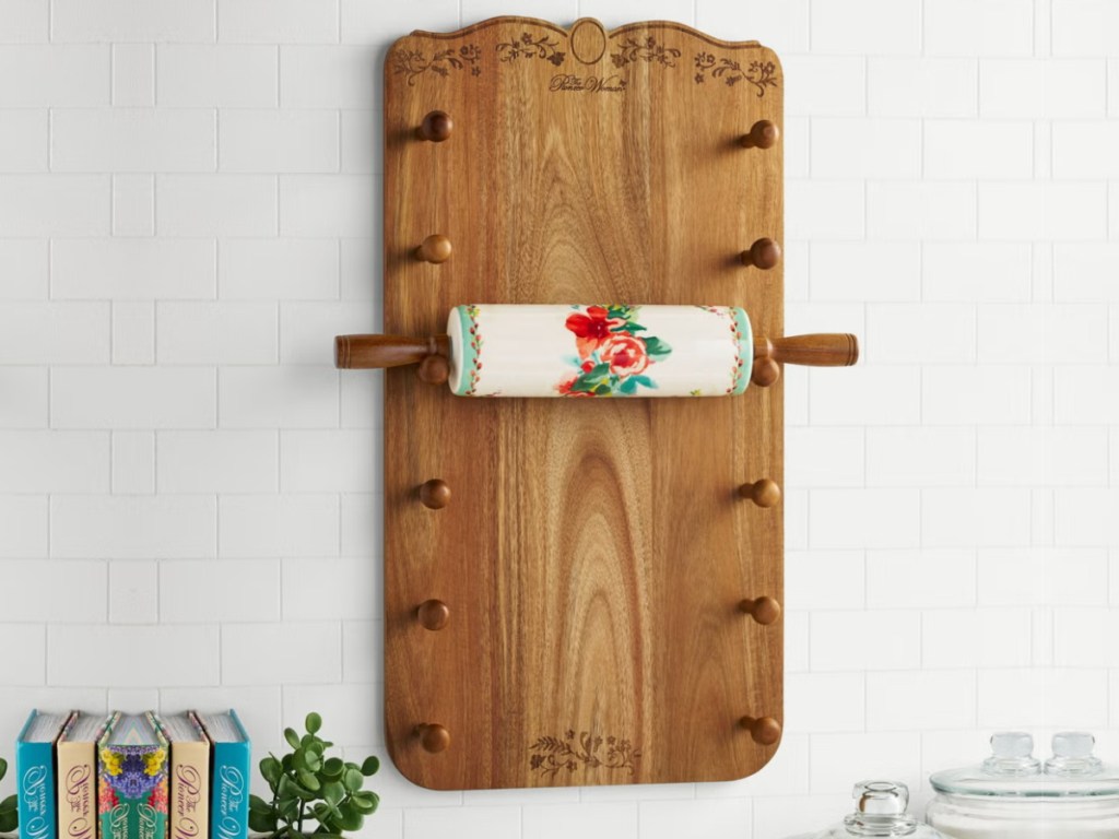 Wooden board mounted on wall with pegs to whole floral rolling pins