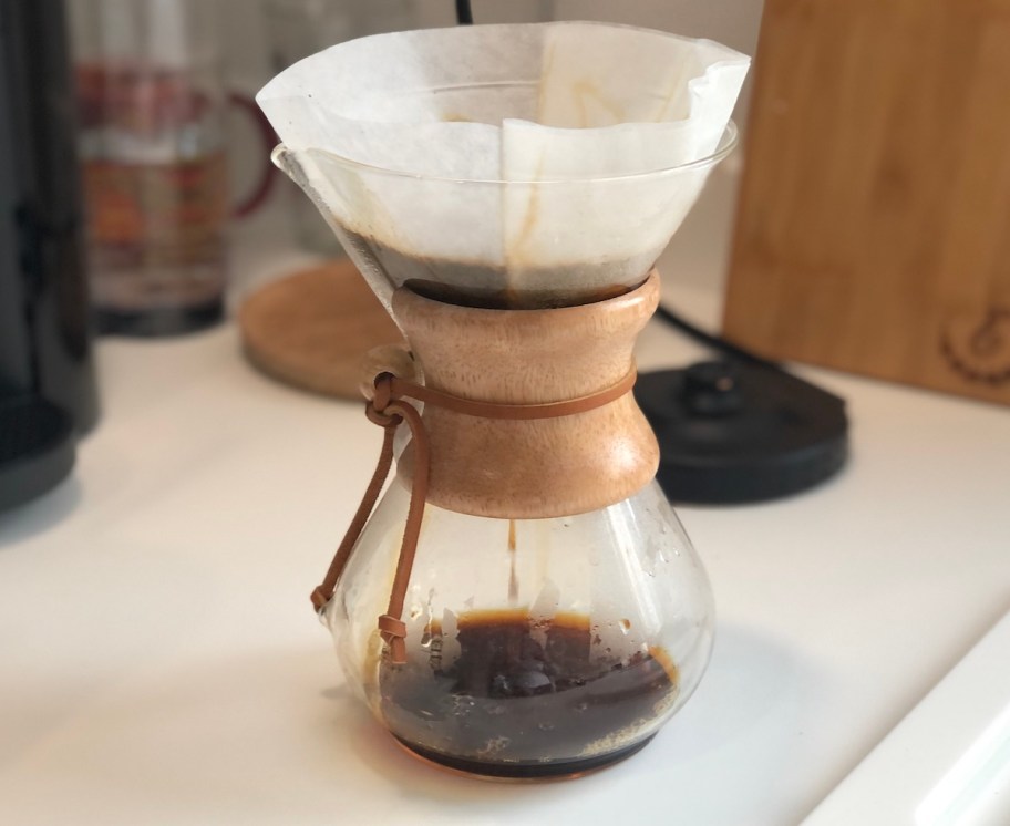 glass coffee maker on white countertop brewing coffee