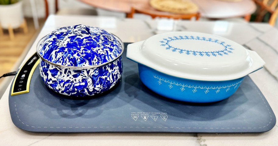 two casserole dishes on a food warming mat tray