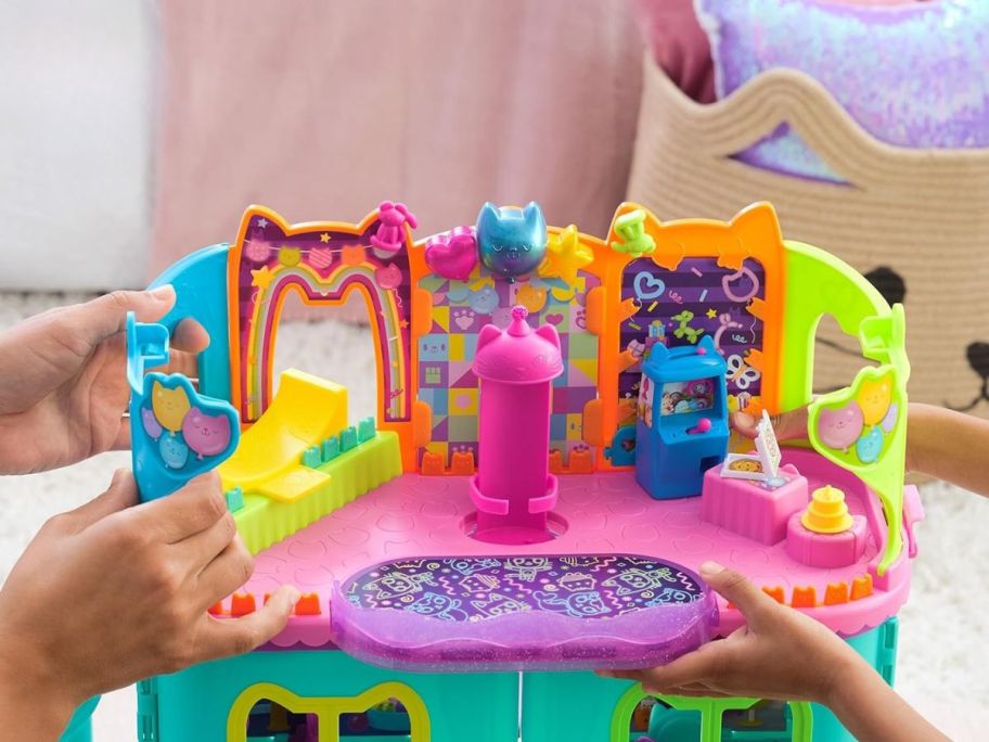 two kids holding Gabby's Dollhouse Party Room Playset 