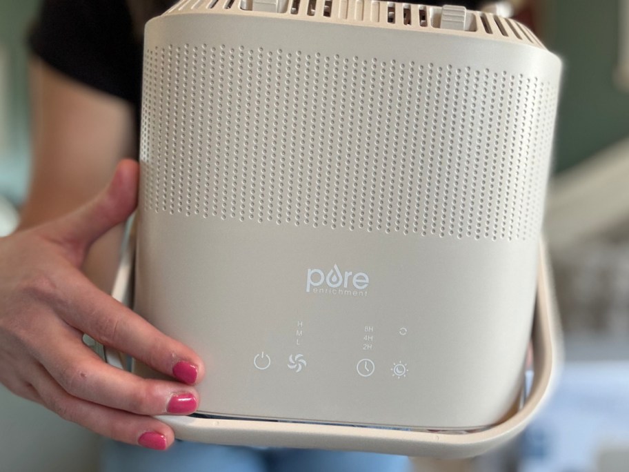 hand holding turned on air purifier