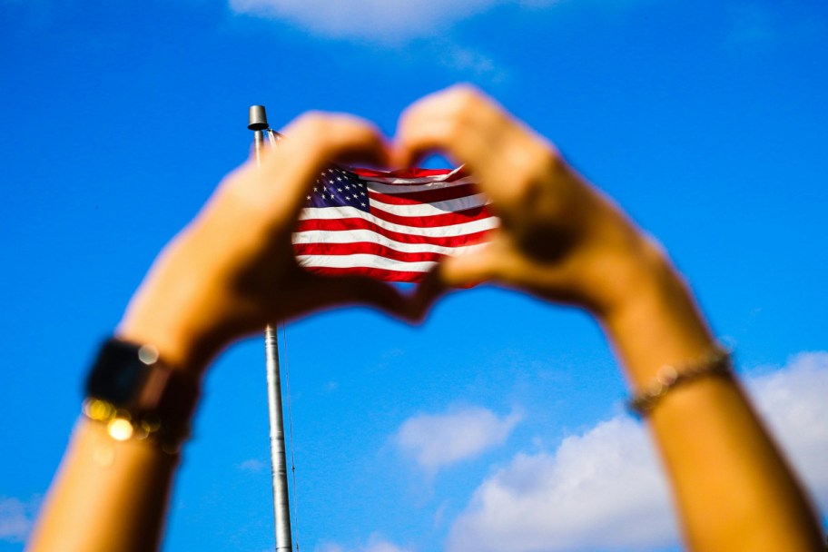 hands making heart around flag