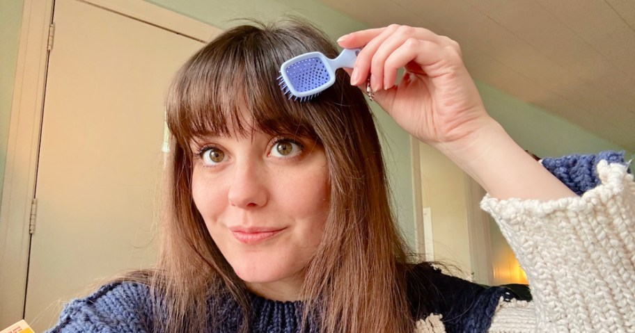 woman using a mini unbrush on her hair