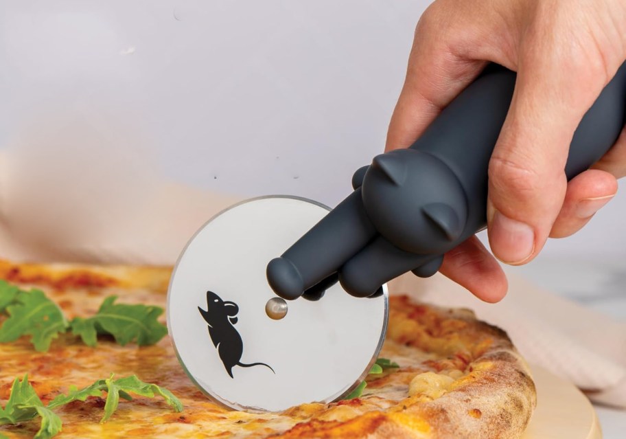 cat shaped pizza cutter cutting into a pizza