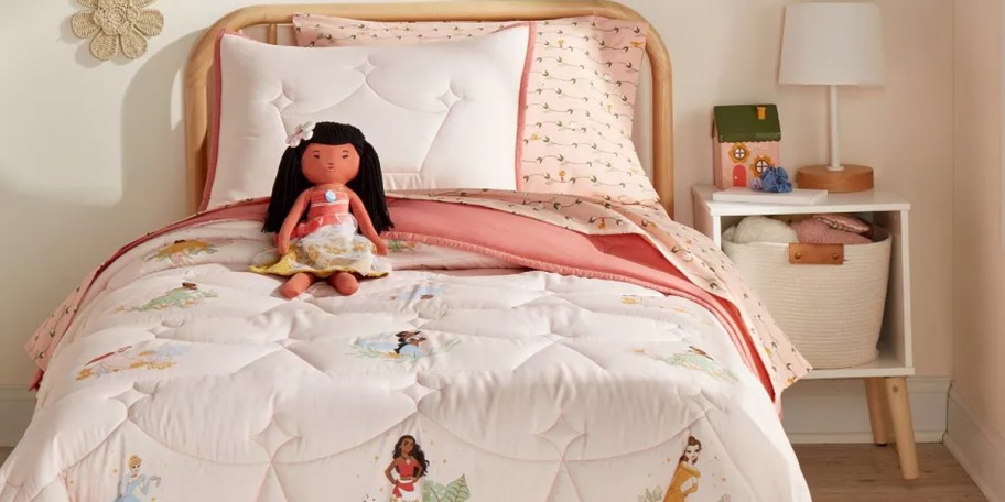 pink princess bedding set with moana doll on bed