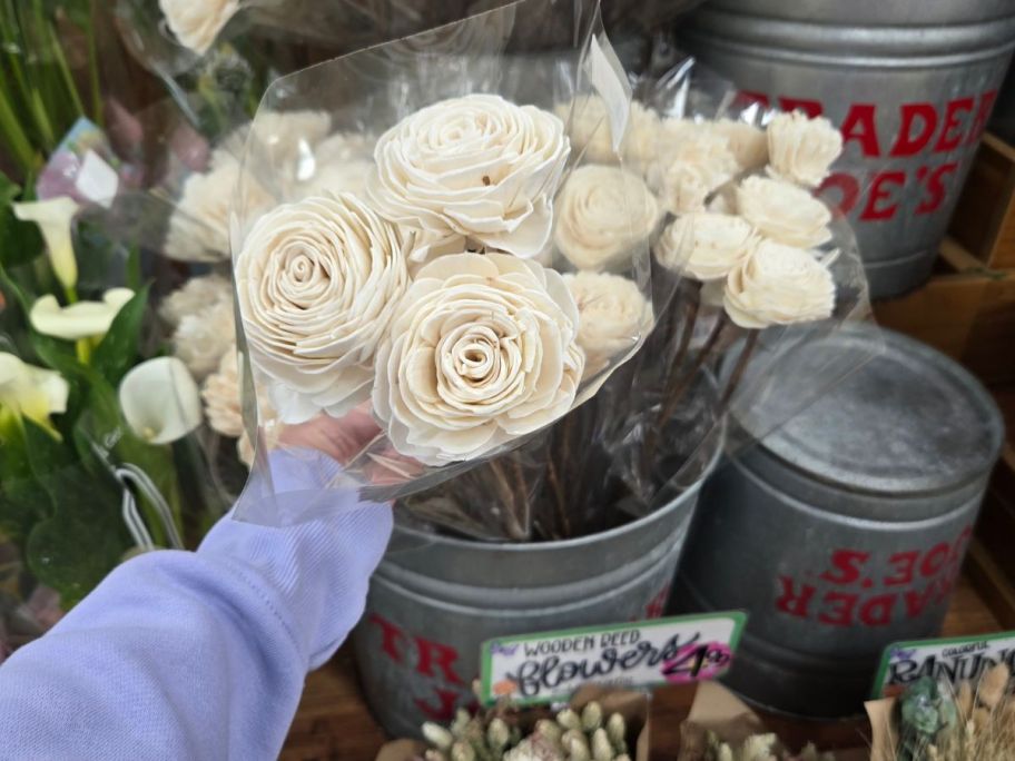 white Wooden Reed Flowers in hand in store