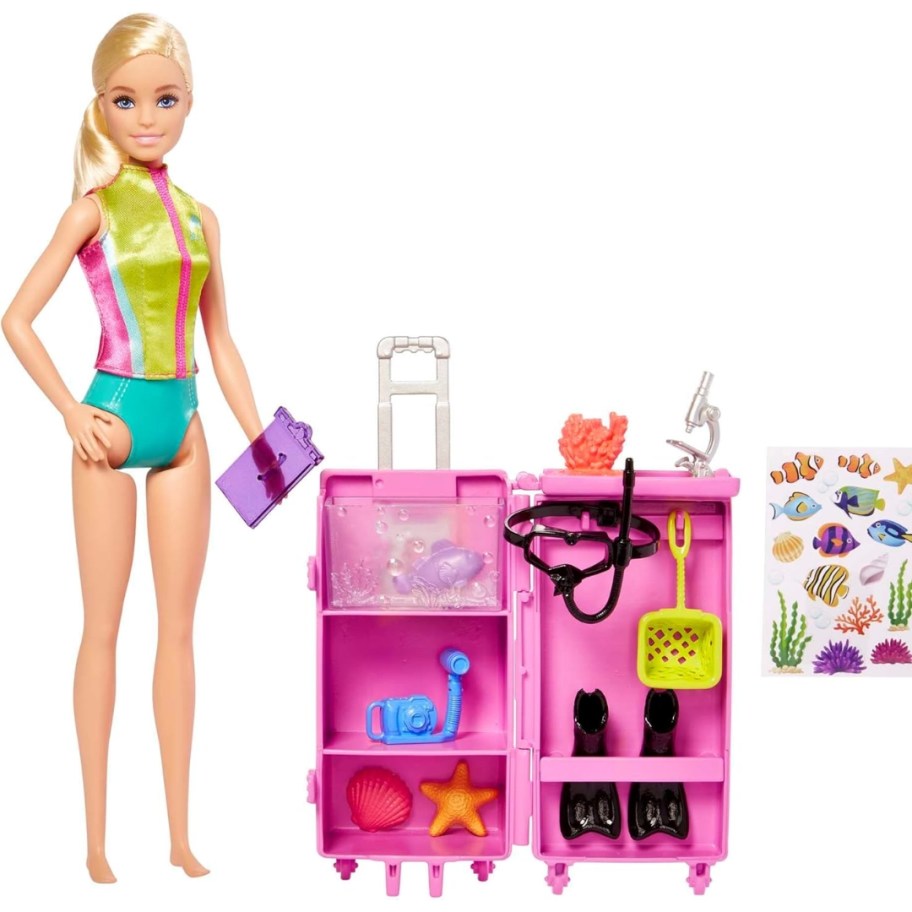 a Barbie doll wearing a swimsuit next to a mobile Marine biologist lab kit toy set and sticker sheets