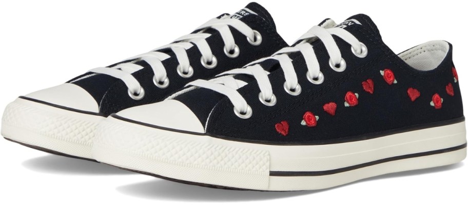 a pair of women's Converse shoes in black with embroidered red roses